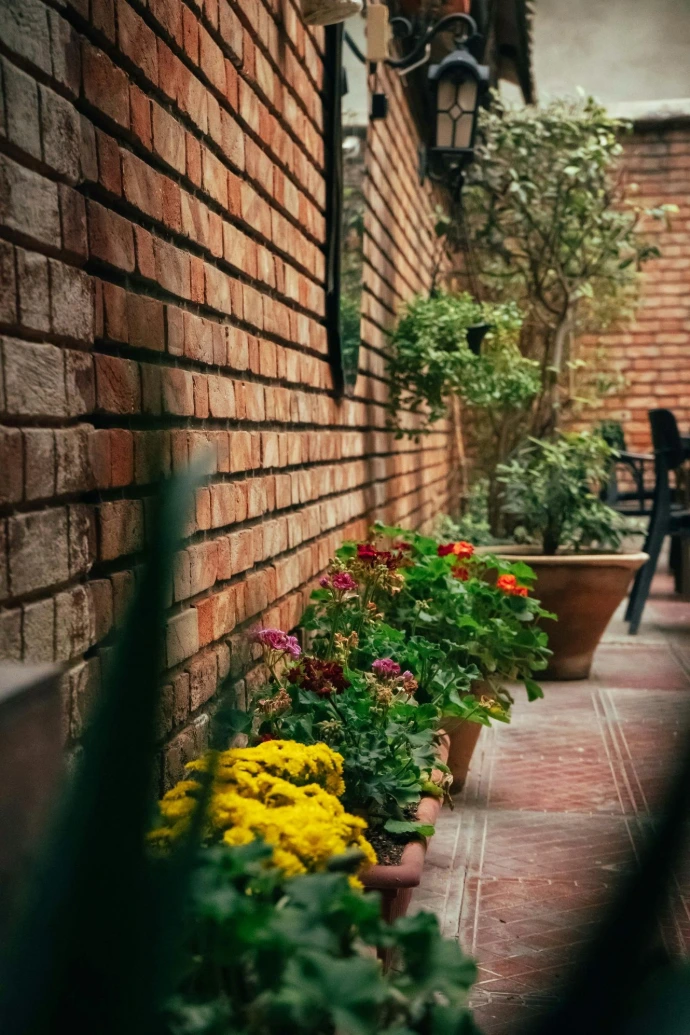 a row of flower pots sitting next to a brick wall